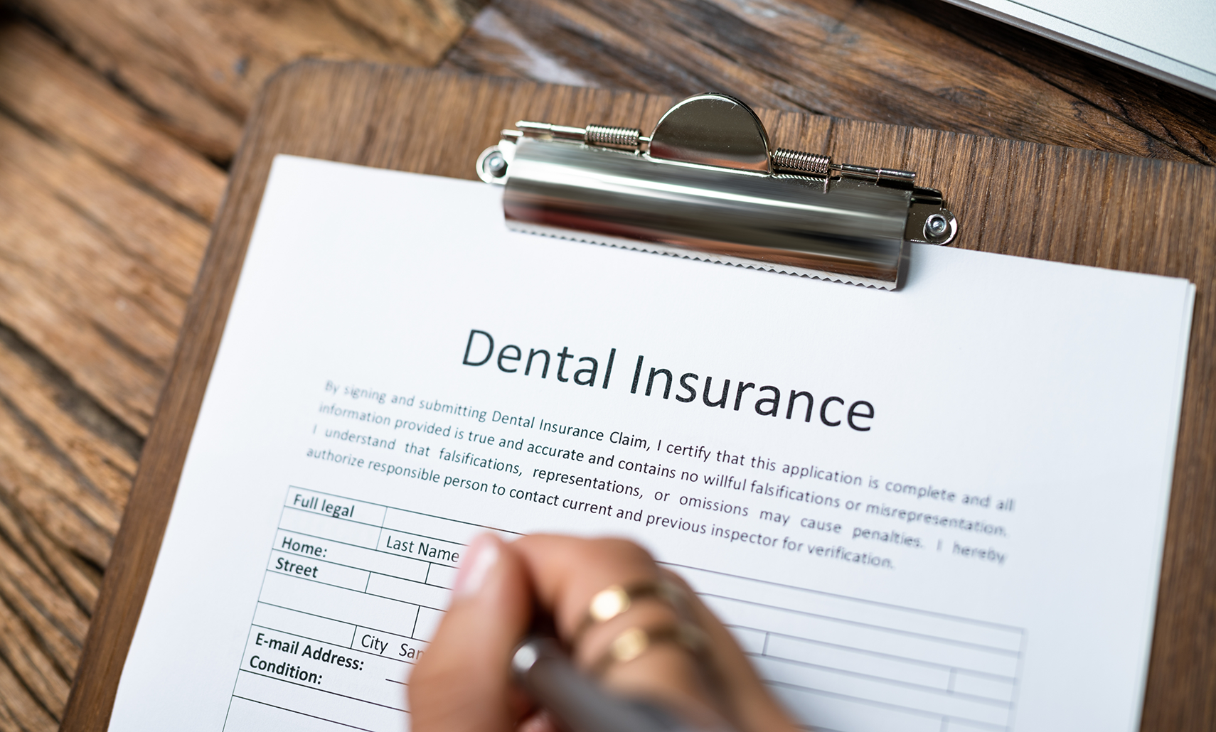 Person filling out a dental insurance form