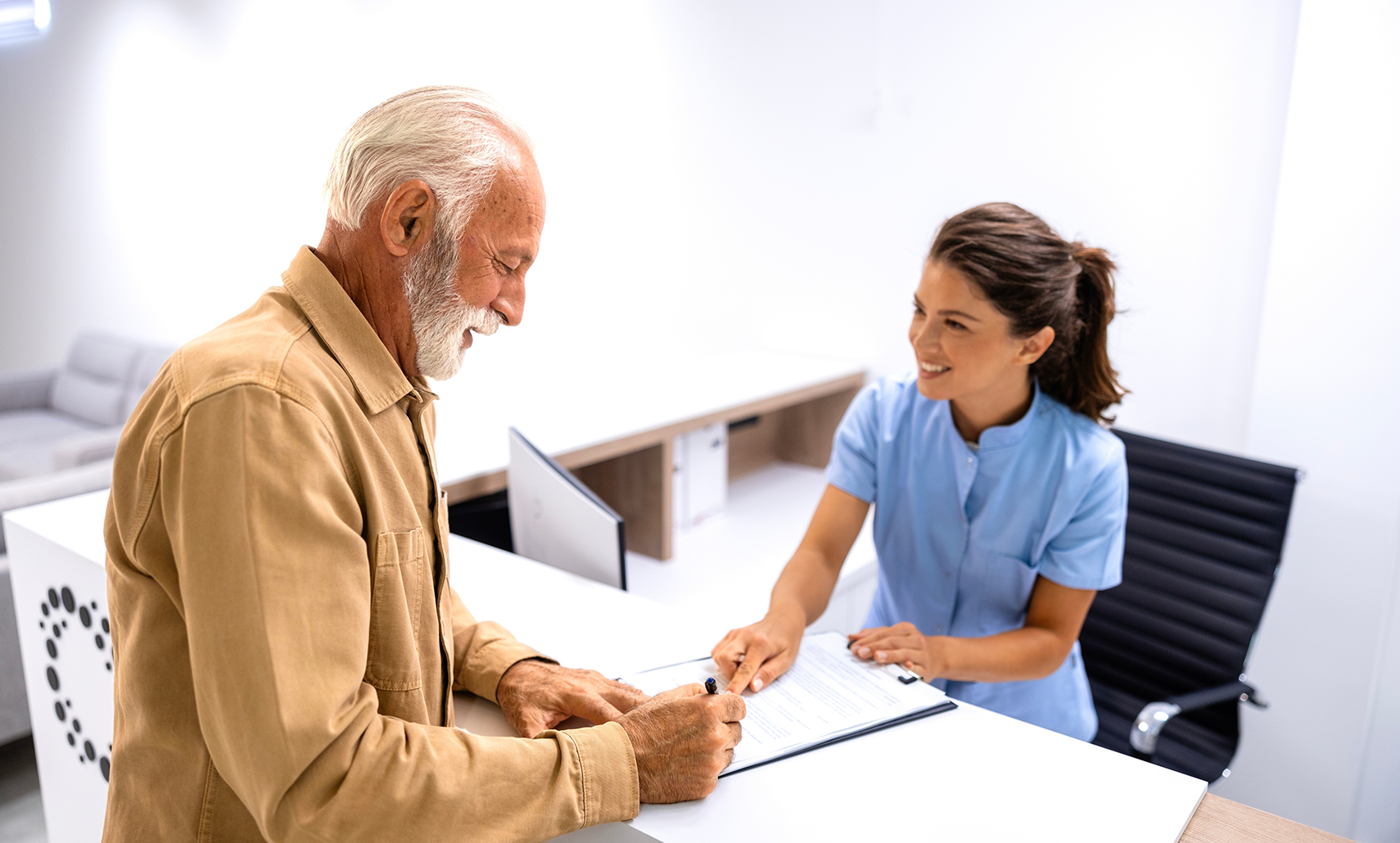 Dental team member helping a new patient complete paperwork