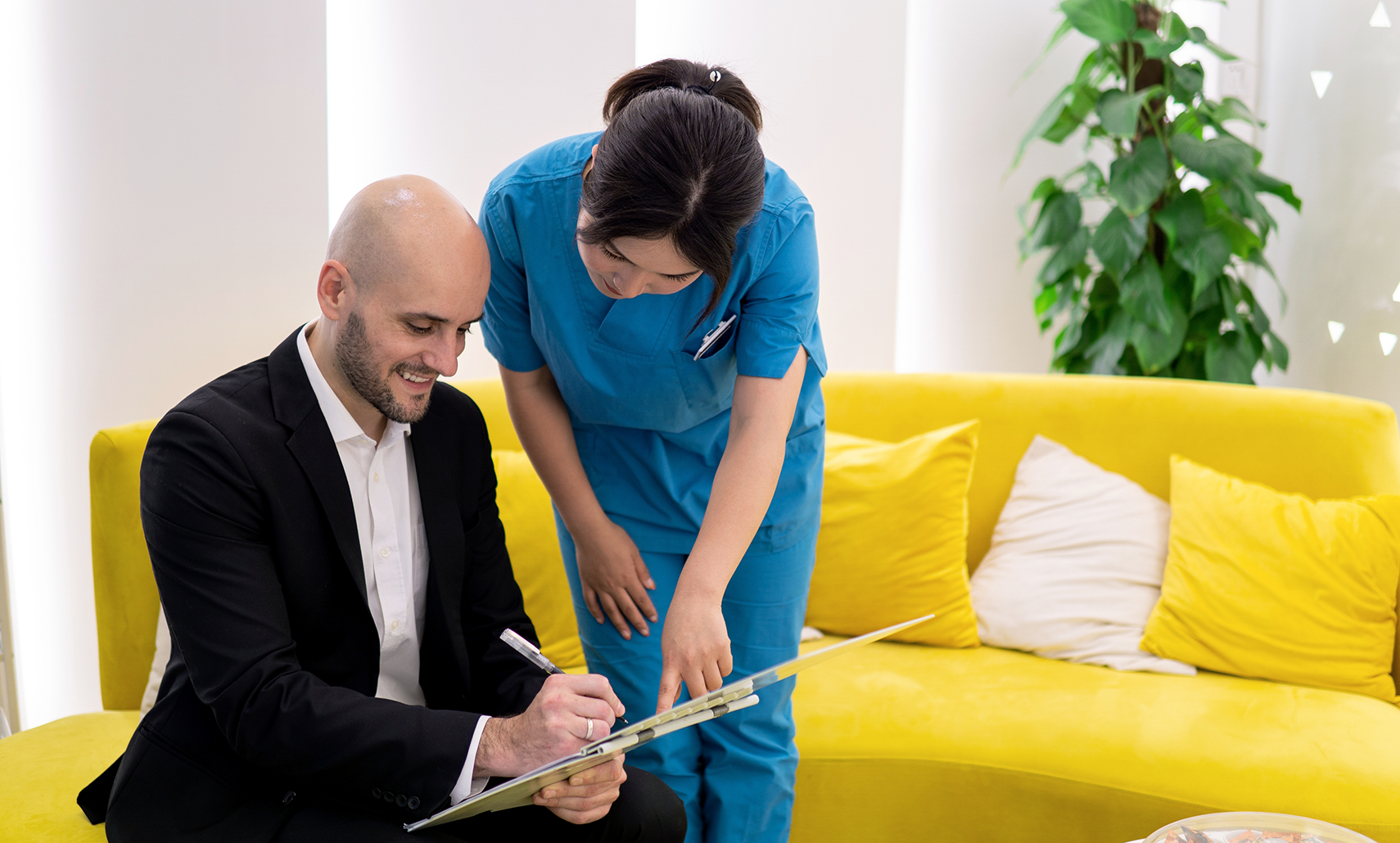 Houston dental team member helping a patient fill out paperwork